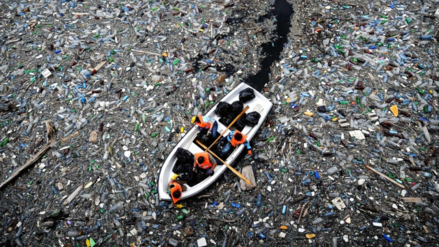 A boat sails through a garbage pat