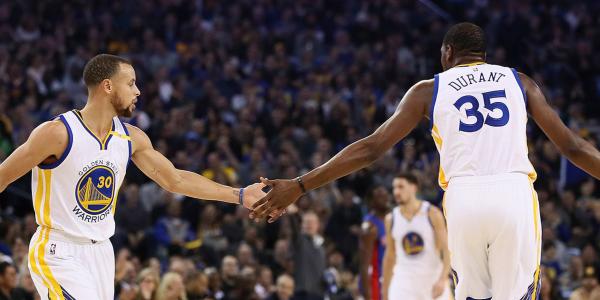 Kevin Durant and Stephen Curry high five during a game
